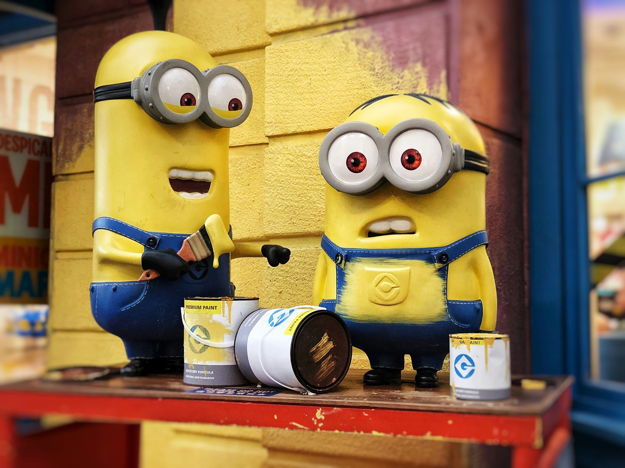 A picture of 2 minions from Despicable Me painting a wall